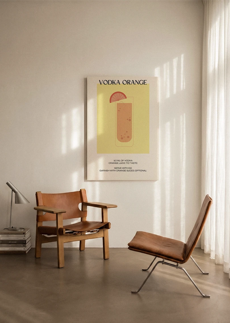 Akustikbillede med en minimalistisk cocktailplakat med Vodka Orange, ophængt over en lænestol ved gardinet