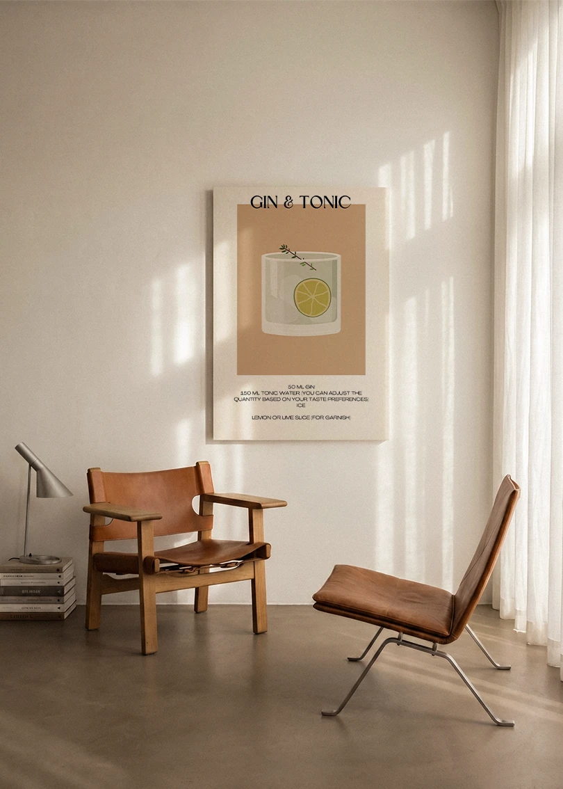 Akustikbillede med en minimalistisk cocktailplakat med Gin & Tonic, ophængt over en lænestol ved gardinet