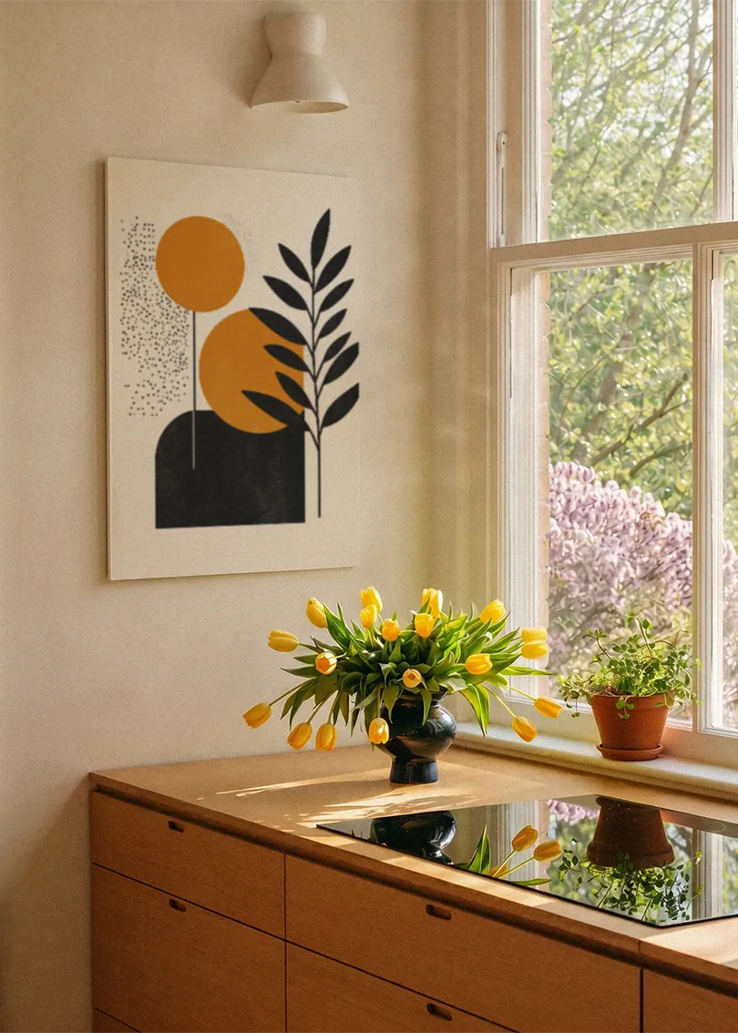 Akustikbillede med orange cirkler med et sort blad, ved et vindue med en blomsterbuket i karmen