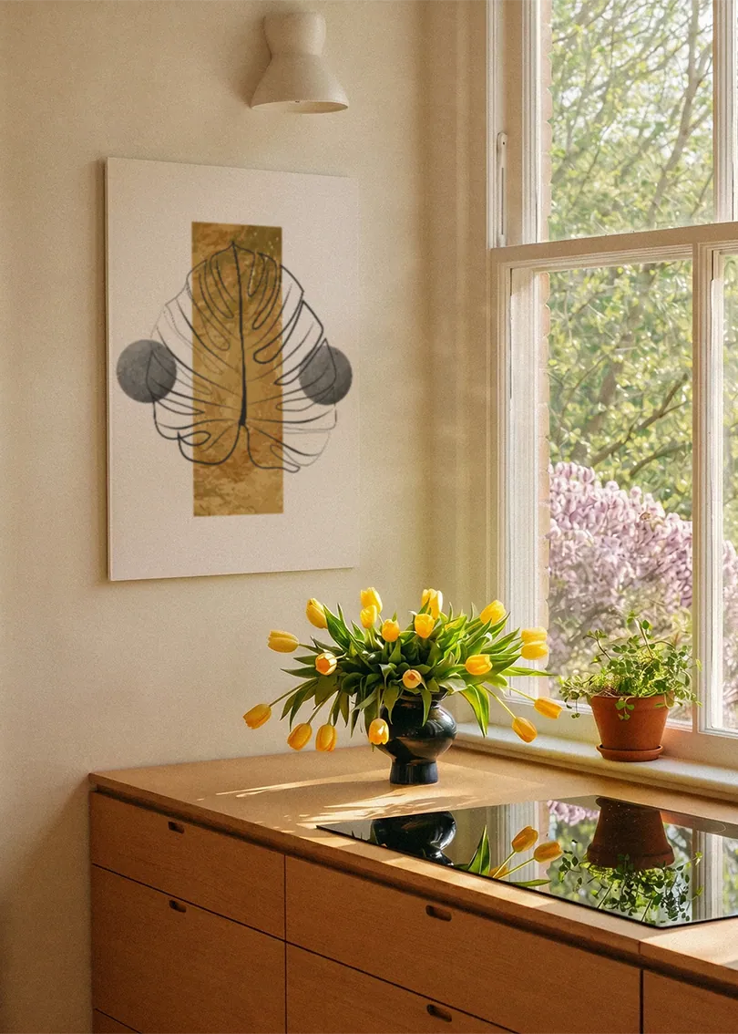 Akustikbillede med et gyldent monsterablad med grå cirkler, ved et vindue med en blomsterbuket i karmen