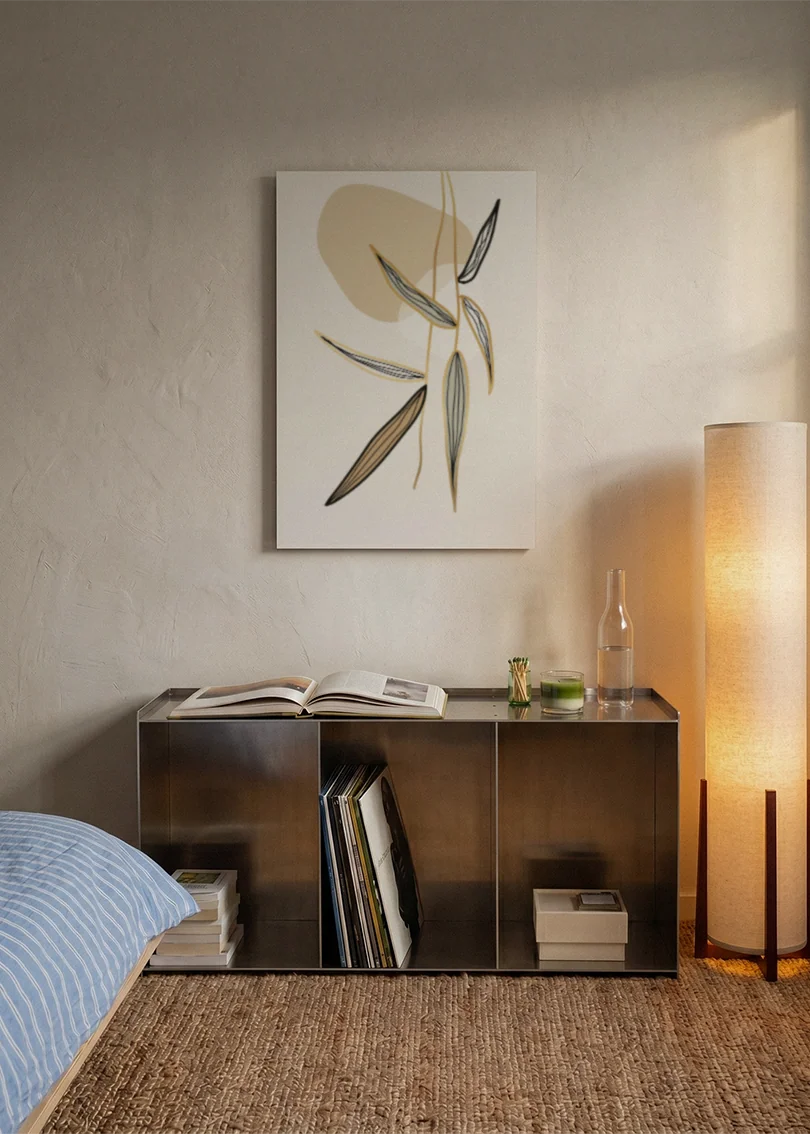 Akustikbillede med beige strå og blade, over sengegavlen i et soveværelse med tændt lampe