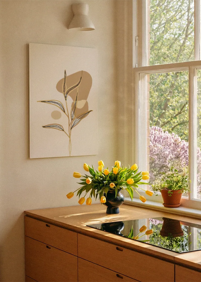 Akustikbillede med et gyldent blad med en brun form, ved et vindue med en blomsterbuket i karmen