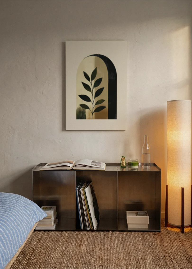 Akustikbillede med en bue med et grønt blad i beige toner, over sengegavlen i et soveværelse med tændt lampe