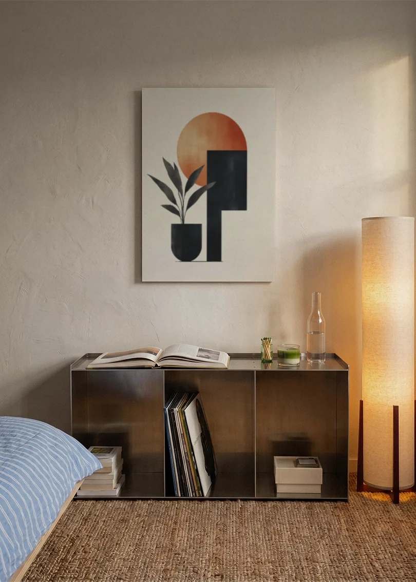 Akustikbillede med en terrakottacirkel med sorte og blå geometriske former, over sengegavlen i et soveværelse med tændt lampe