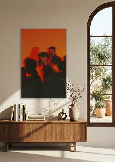 Akustikbillede med silhuetter af mennesker i orange lys, ved et buet vindue med reol