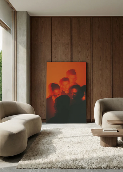 Akustikbillede med en menneskemængde i orange lys, i en lounge med bugtet sofa mod valnød