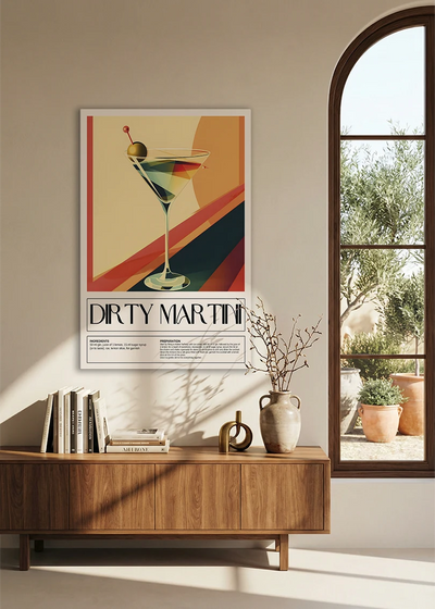 Akustikbillede med en retro cocktailplakat med Dirty Martini, over en skænk i valnød ved et buet vindue