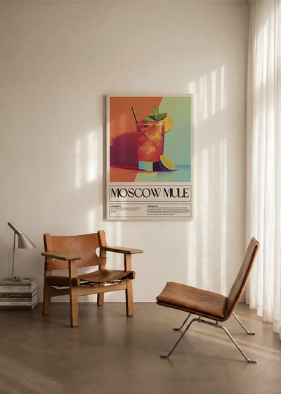 Akustikbillede med en retro cocktailplakat med Moscow Mule, ophængt over en lænestol ved gardinet