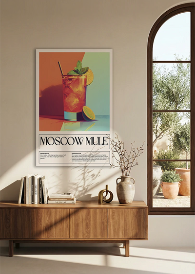Akustikbillede med en retro cocktailplakat med Moscow Mule, over en skænk i valnød ved et buet vindue