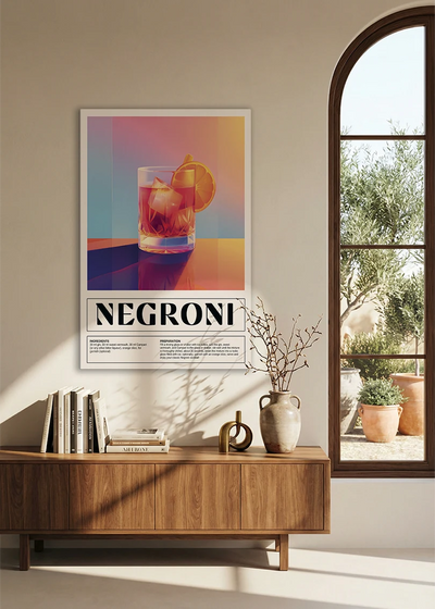 Akustikbillede med en retro cocktailplakat med Negroni, over en skænk i valnød ved et buet vindue