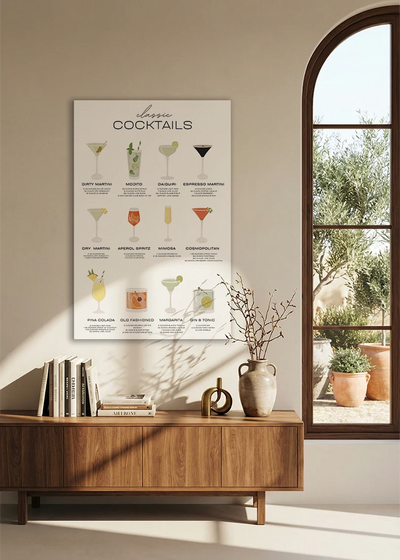Akustikbillede med en oversigtsplakat med klassiske cocktails, over en skænk i valnød ved et buet vindue