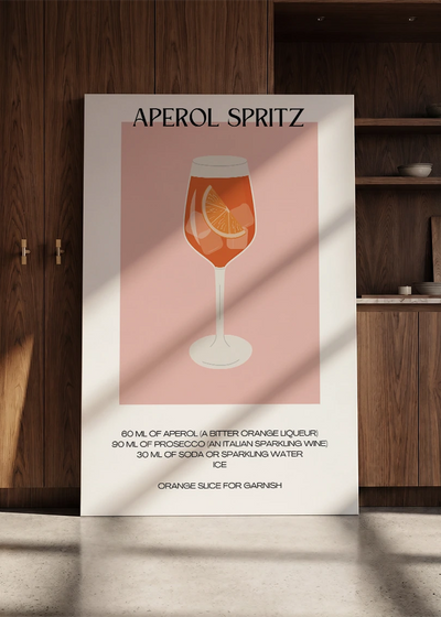 Akustikbillede med en minimalistisk cocktailplakat med Aperol Spritz, lænet mod en skabsvæg i valnød