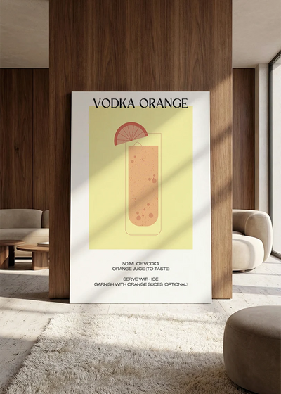 Akustikbillede med en minimalistisk cocktailplakat med Vodka Orange, lænet mod vægpanel i valnød ved sofaen