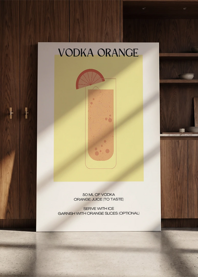 Akustikbillede med en minimalistisk cocktailplakat med Vodka Orange, lænet mod en skabsvæg i valnød