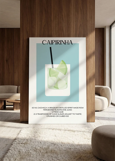 Akustikbillede med en minimalistisk cocktailplakat med Caipirinha, lænet mod vægpanel i valnød ved sofaen