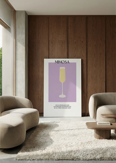 Akustikbillede med en minimalistisk cocktailplakat med Mimosa, i en lounge med bugtet sofa mod vægpanel i valnød
