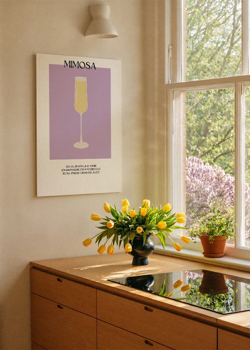 Akustikbillede med en minimalistisk cocktailplakat med Mimosa, ved et køkkenvindue med gule tulipaner