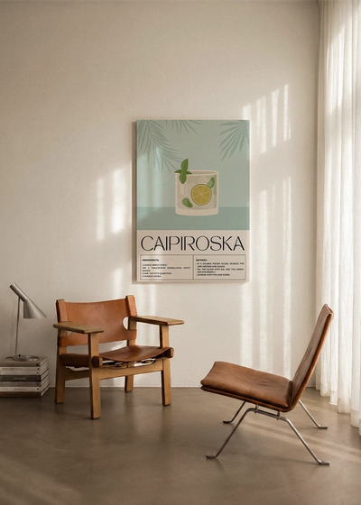 Akustikbillede med en retro cocktailplakat med Caipiroska, ophængt over en lænestol ved gardinet