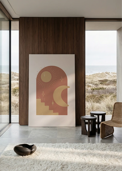 Akustikbillede med en terrakottafarvet sol og måne med en trappe, i stort format ved et panoramavindue med havudsigt