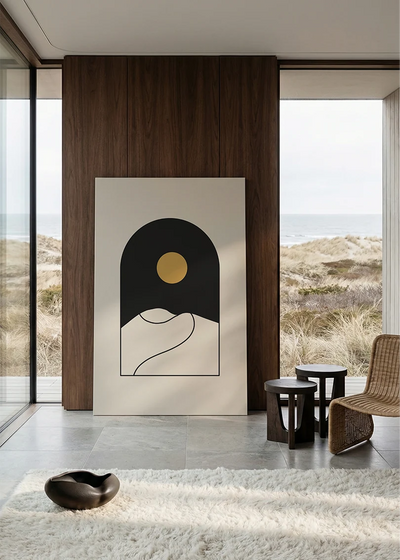 Akustikbillede med en sort bue med gylden sol over bakker, i stort format ved et panoramavindue med havudsigt