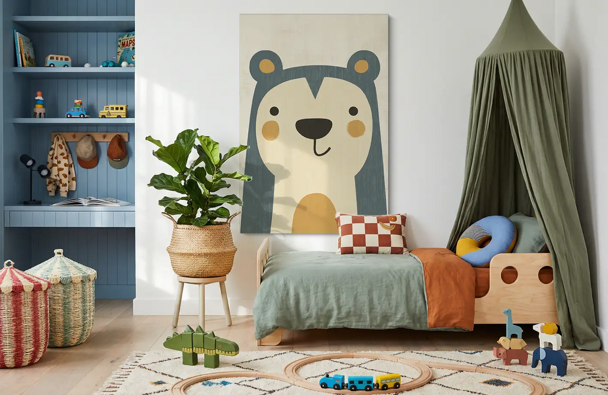 Akustikbillede med en enkel illustration af en bjørn i blåt, i et børneværelse med grøn sengehimmel og blå reol