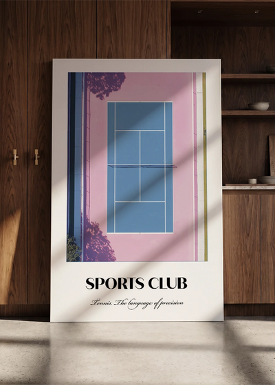 Akustikbillede med en sportsplakat med en tennisbane set fra oven i lyserødt og blåt, lænet mod en skabsvæg i valnød